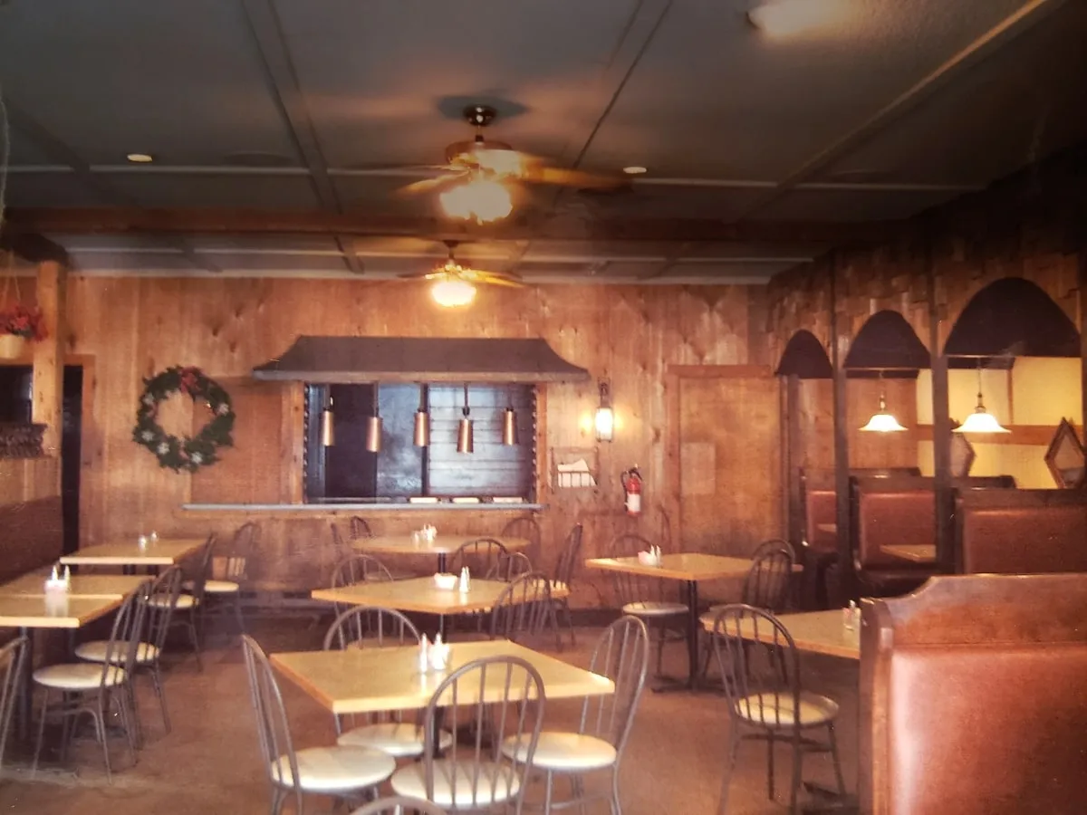 Restaurant dining room with wood-paneled walls and pendant lighting