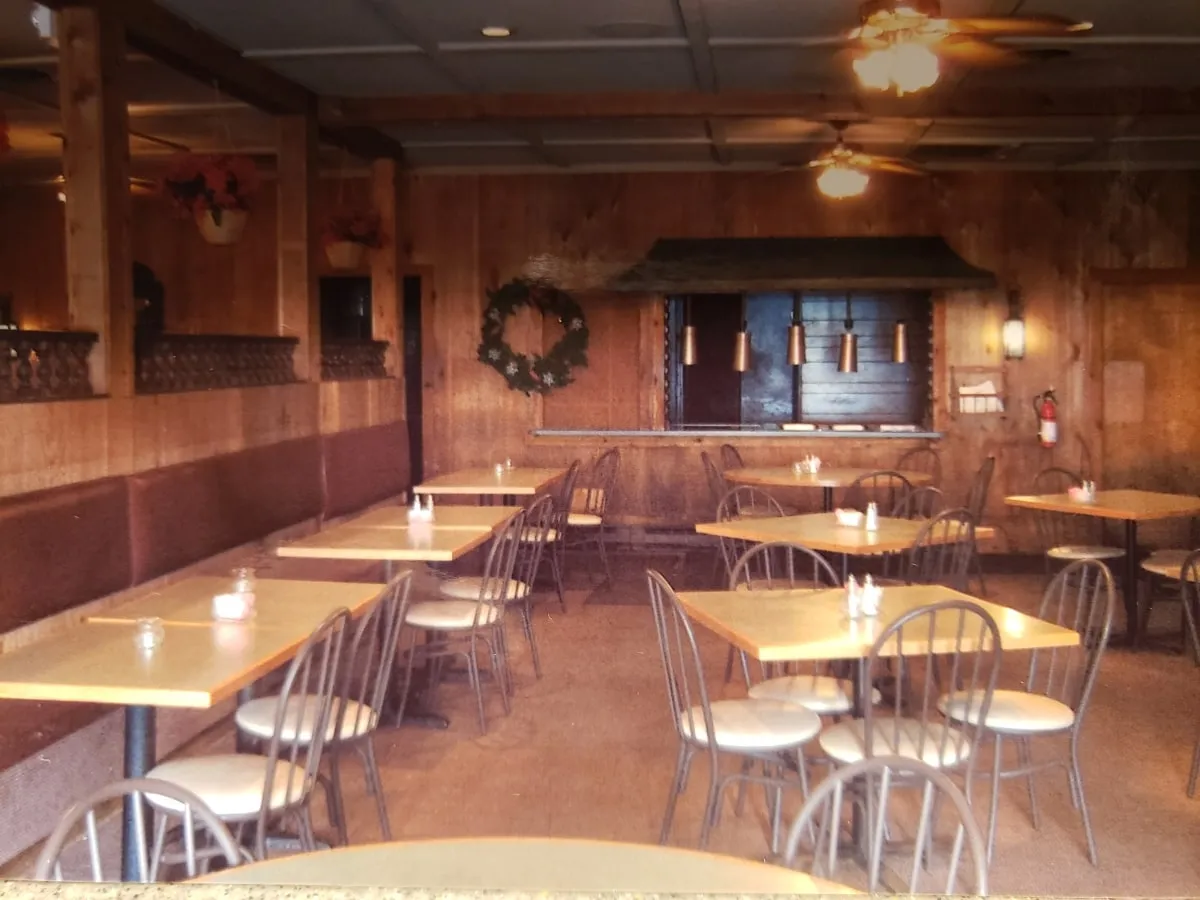 Restaurant seating area with wood booths, tables and ceiling fans