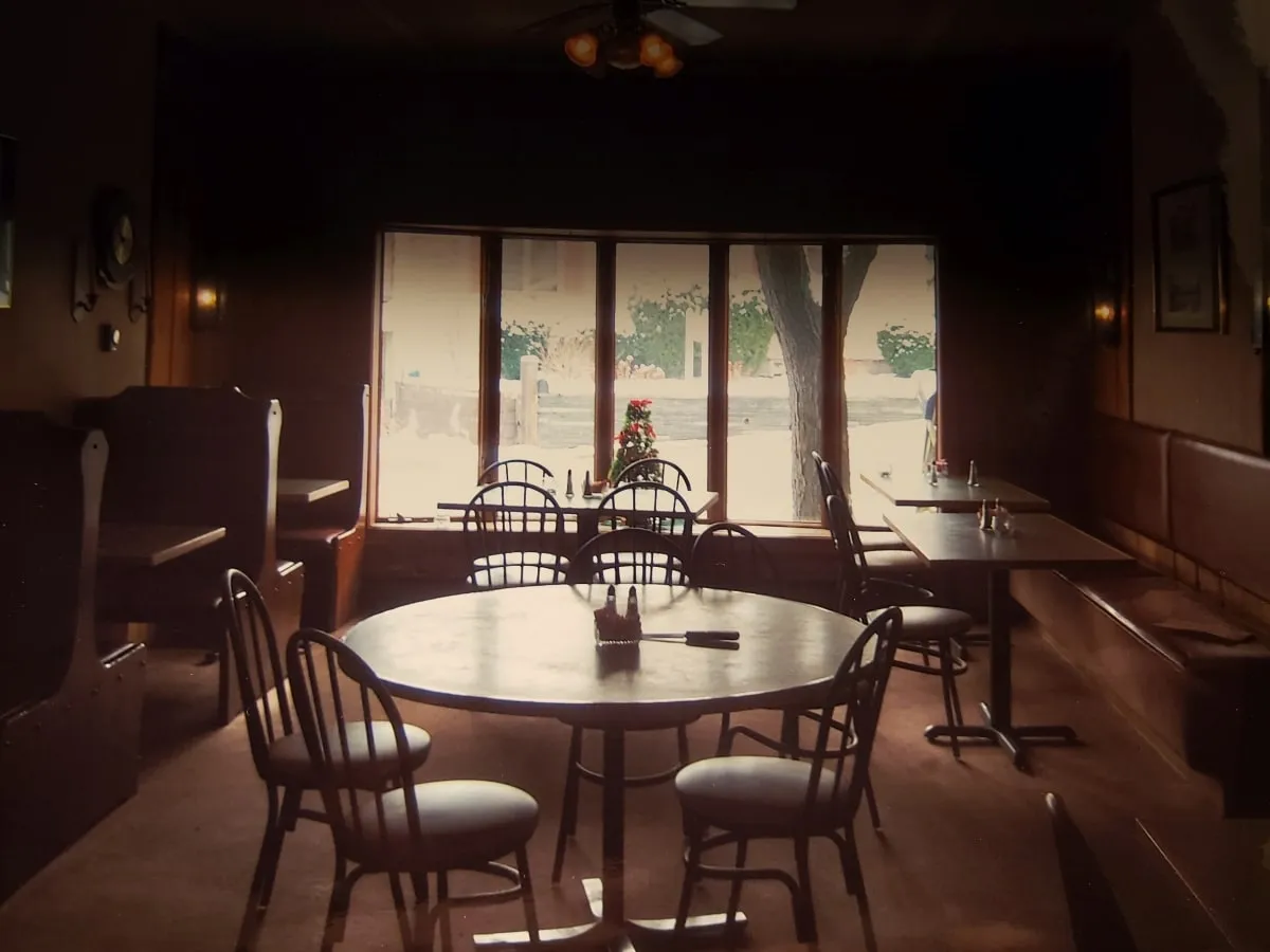 Dining room with round tables set beside a wall of windows