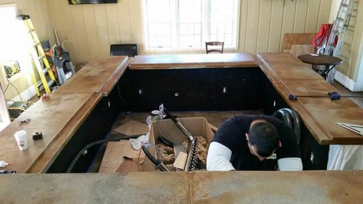 Crew member fitting the countertop on a custom-built bar
