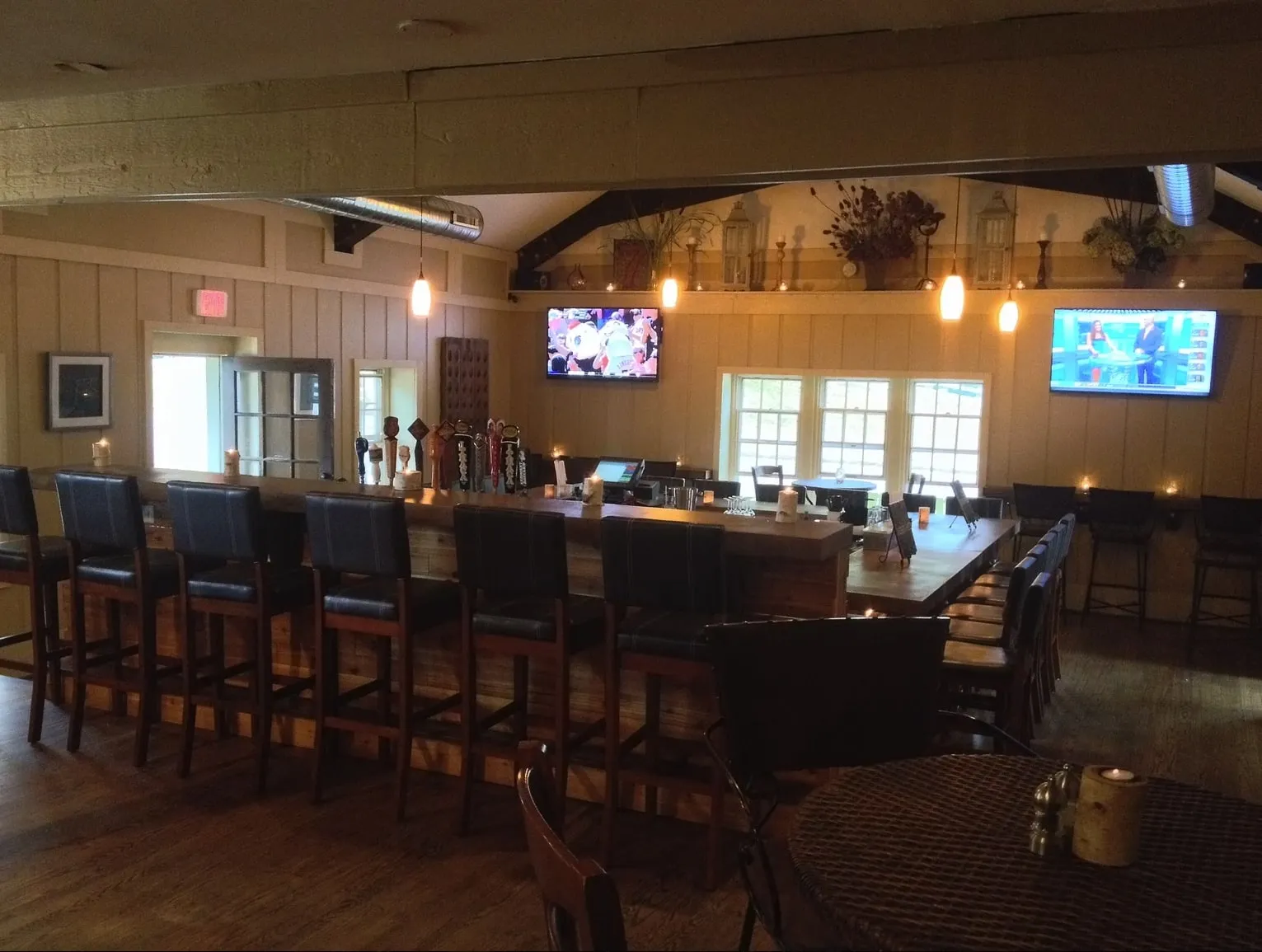 Finished restaurant bar with pendant lighting, wood bar top and bar stools