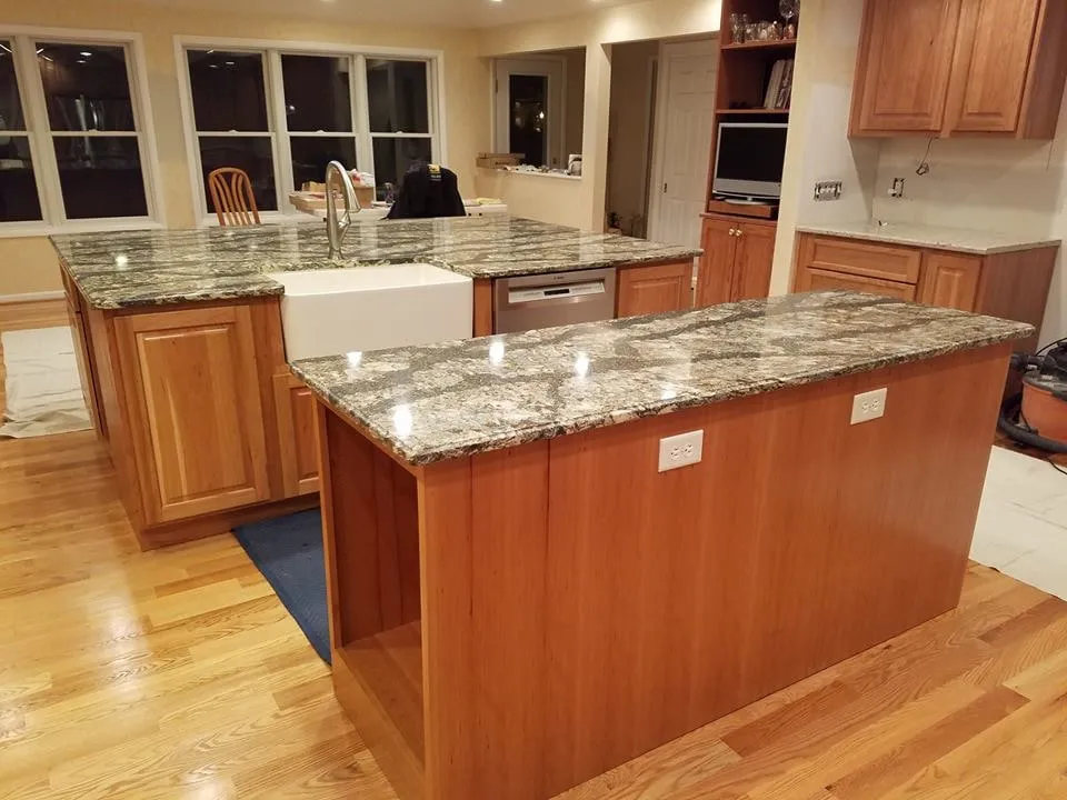 Bright remodeled kitchen with a large granite island, farmhouse sink and hardwood floors