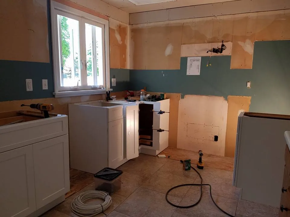 Kitchen mid-renovation with cabinets removed and new drywall going up