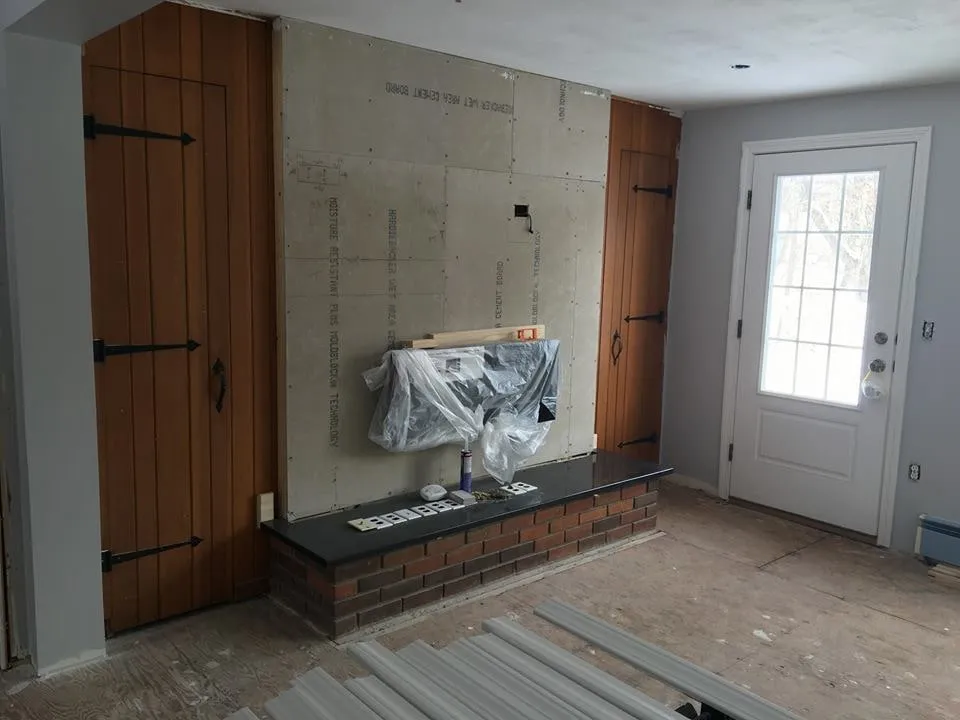 Living room with a stone fireplace surround under construction