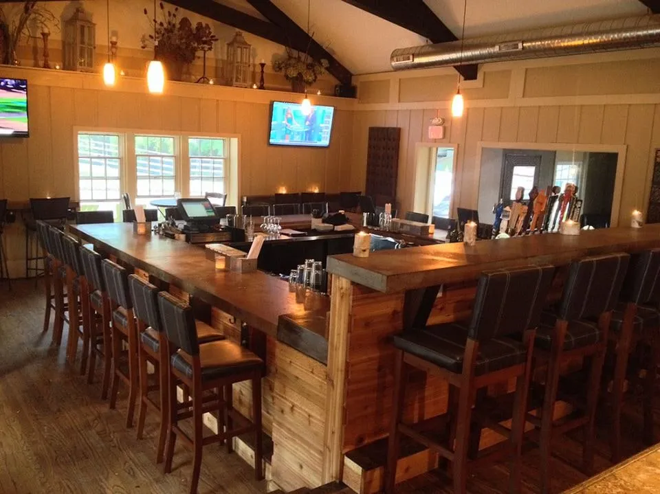 Finished basement bar with a vaulted wood ceiling, pendant lighting and bar stools