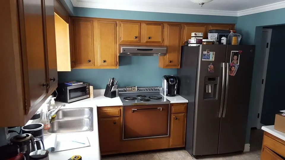 Kitchen with wood cabinets, blue painted walls and stainless appliances