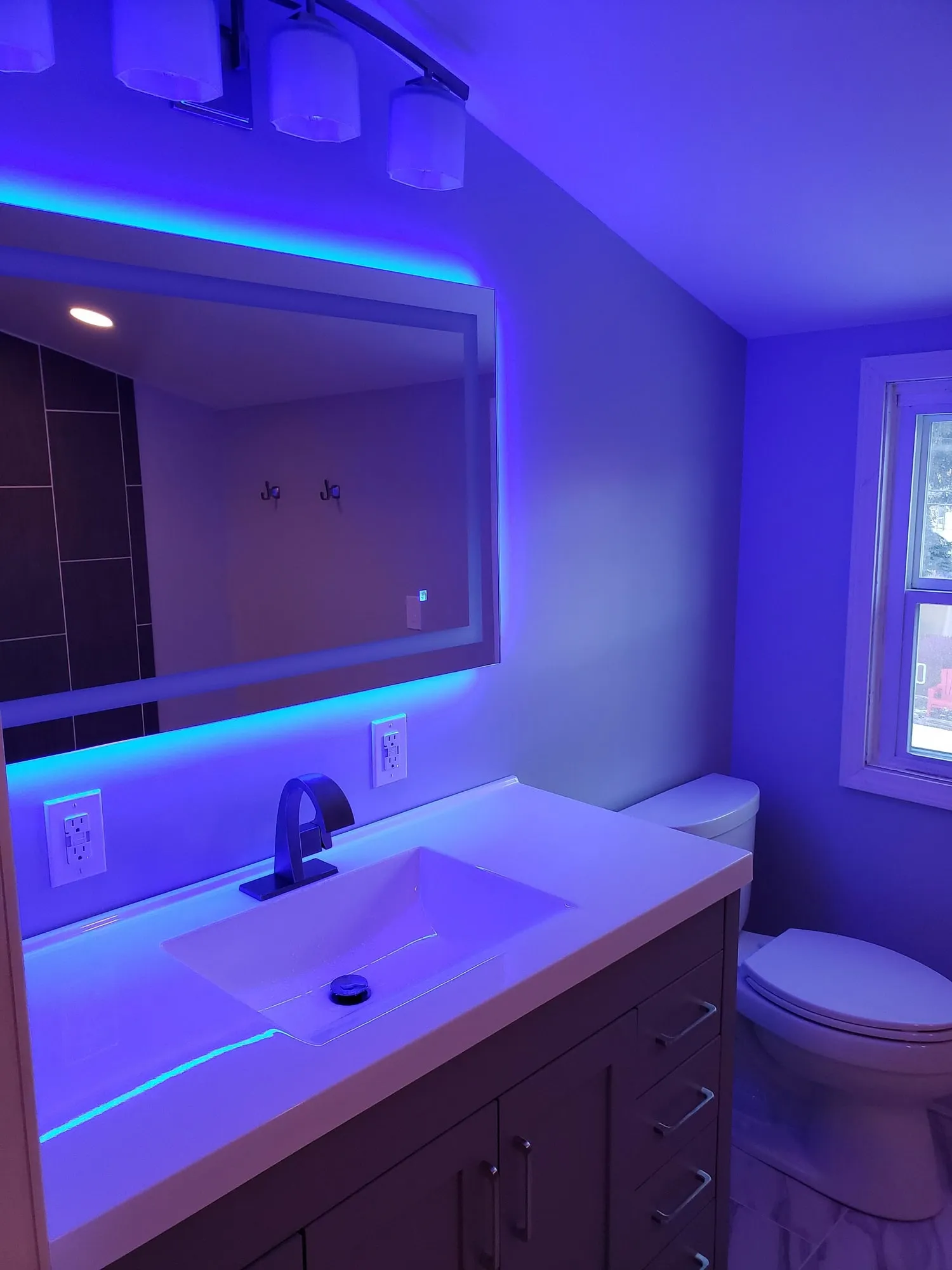 Finished bathroom vanity with vessel sink and backlit mirror